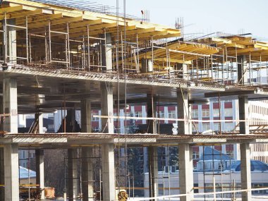 Kentsel gelişim. Gündüz vakti inşaat alanında. Üniformalı işçiler iskeleyi hazırlayın.