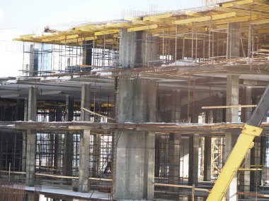 Kentsel gelişim. Gündüz vakti inşaat alanında. Üniformalı işçiler iskeleyi hazırlayın.