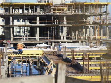 Kentsel gelişim. Gündüz vakti inşaat alanında. Üniformalı işçiler iskeleyi hazırlayın.