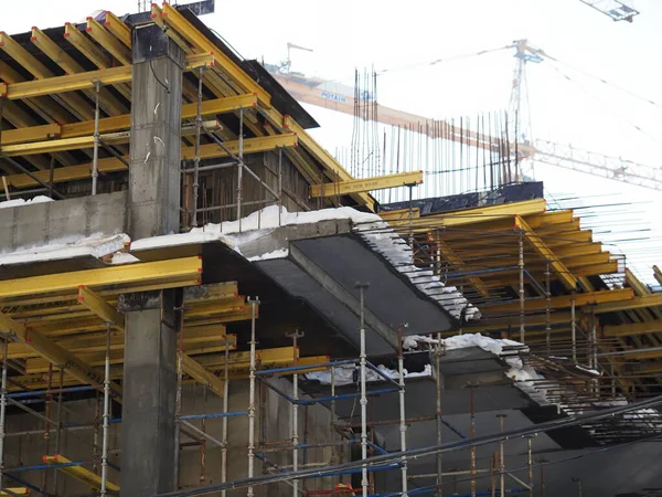 Kentsel gelişim. Gündüz vakti inşaat alanında. Üniformalı işçiler iskeleyi hazırlayın.