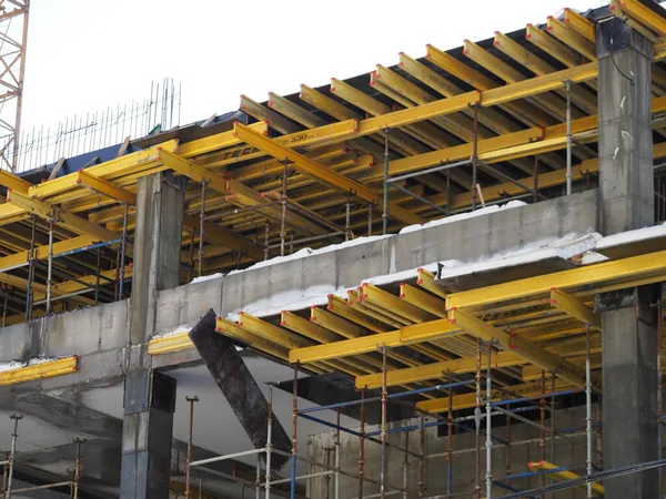 urban development. construction site in winter during the day. workers in uniform prepare the scaffolding