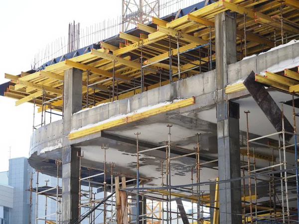 Kentsel gelişim. Gündüz vakti inşaat alanında. Üniformalı işçiler iskeleyi hazırlayın.