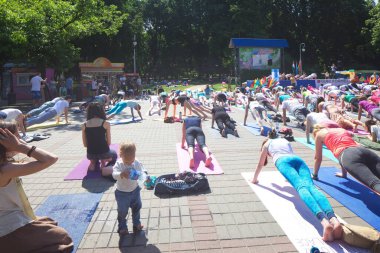 Belarus, Minsk, 2016. Uluslararası yoga günü festivali sırasında parkta egzersiz yapan insanlar