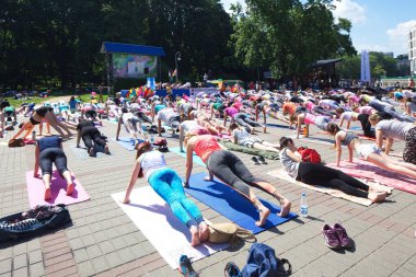 Belarus, Minsk, 2016. Uluslararası yoga günü festivali sırasında parkta egzersiz yapan insanlar