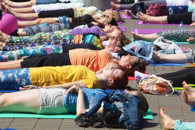 Belarus, Minsk, 2016. Uluslararası yoga günü festivali sırasında parkta egzersiz yapan insanlar