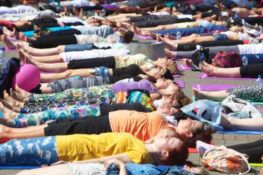 Belarus, Minsk, 2016. Uluslararası yoga günü festivali sırasında parkta egzersiz yapan insanlar