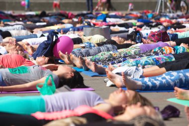 Belarus, Minsk, 2016. Uluslararası yoga günü festivali sırasında parkta egzersiz yapan insanlar