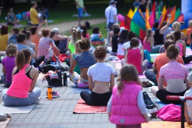 Belarus, Minsk, 2016. Uluslararası yoga günü festivali sırasında parkta egzersiz yapan insanlar