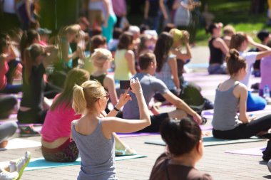 Belarus, Minsk, 2016. Uluslararası yoga günü festivali sırasında parkta egzersiz yapan insanlar