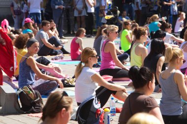 Belarus, Minsk, 2016. Uluslararası yoga günü festivali sırasında parkta egzersiz yapan insanlar