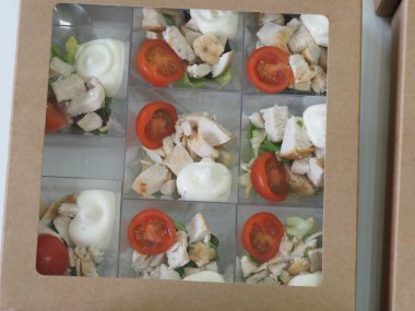 Sandviçleri karton paketlere, porsiyonlara, yemek servislerine koy.