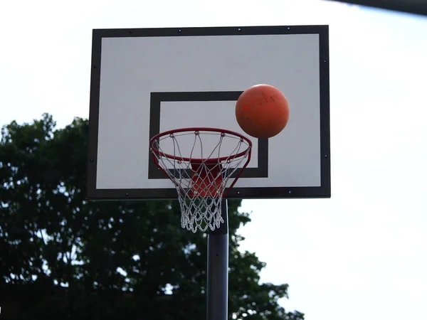 ボールは試合中に路上のバスケットボール フープに飛び込み — ストック写真