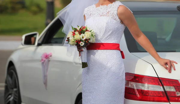 Braut mit Blumenstrauß neben dem Auto — Stockfoto
