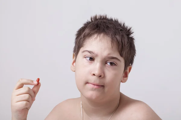 Boy taking medicine pill Stock Photo