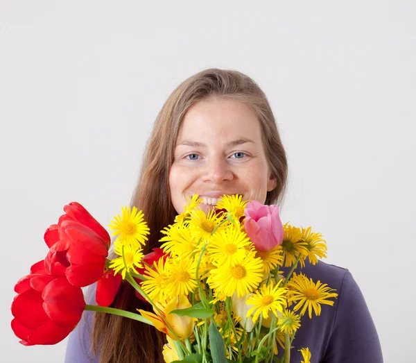 Beautiful young woman holding flowers — Stock Photo, Image