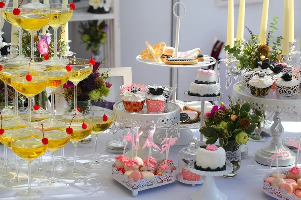 Vasos con champán y pasteles dulces — Foto de Stock