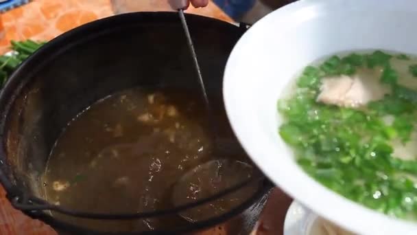 Koch gießt Suppe in Schüssel — Stockvideo