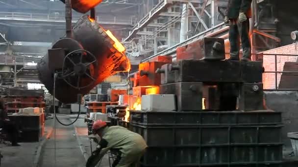 Рабочие, разливающие расплавленное железо — стоковое видео