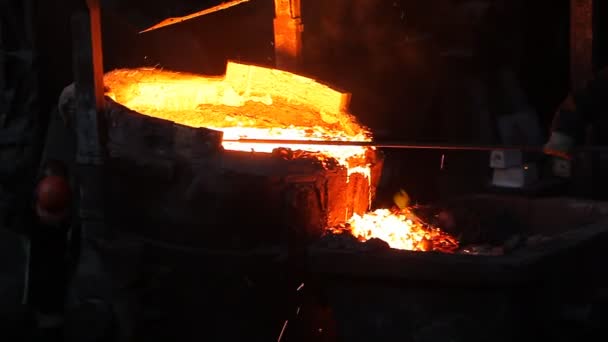 Рабочие, разливающие расплавленное железо — стоковое видео