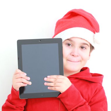 Tablet ile Noel Baba şapkalı çocuk