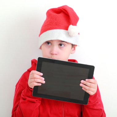 Tablet ile Noel Baba şapkalı çocuk