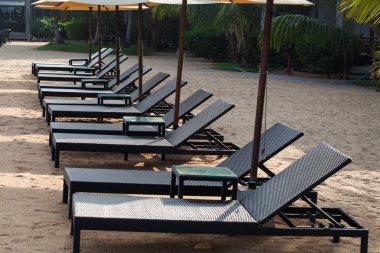 Plajda şemsiye altında şezlong