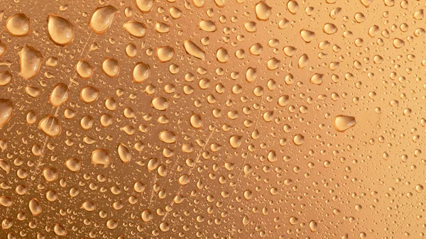 Druppels water op gouden oppervlak — Stockfoto