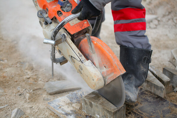 Construction worker using concrete saw