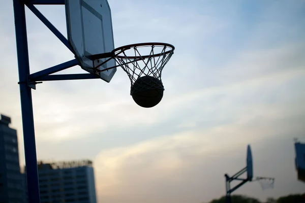 Basketball spielen bei Sonnenuntergang — Stockfoto