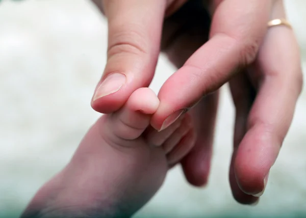 Baba lábát szülő kéz — Stock Fotó