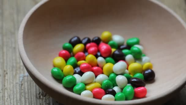 Caramelos de colores en un plato — Vídeo de stock