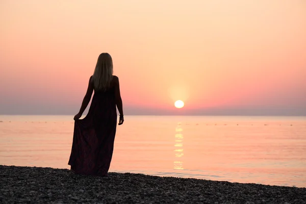 Girl on the beach at sunrise — Stock Photo, Image