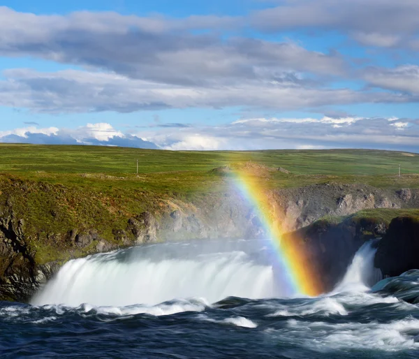 Летний пейзаж с водопадом и радугой в Исландии — стоковое фото