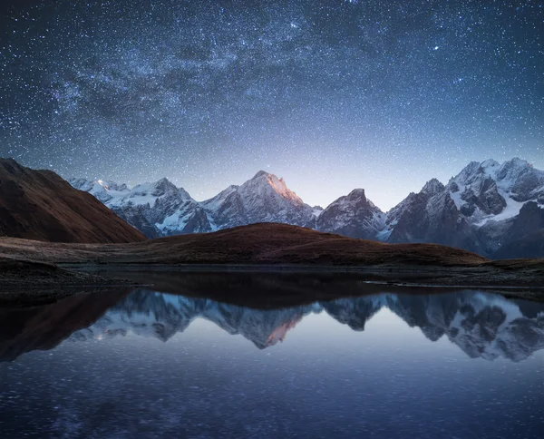 Night landscape with a mountain lake and a starry sky