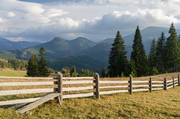 Paisaje de verano con una valla de madera en un pueblo de montaña —  Fotos de Stock