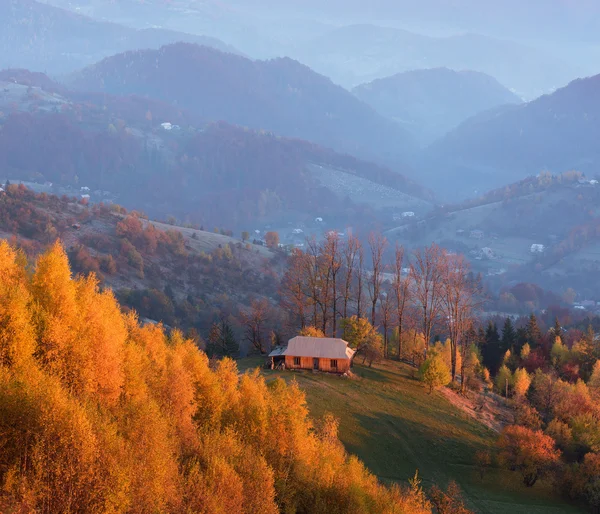 Paisaje otoñal con una casa de madera en las montañas — Foto de Stock