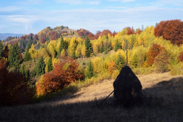 Herbstlandschaft mit Heuhaufen in den Bergen — Stockfoto