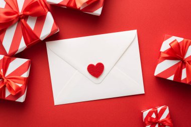 Kırmızı renkli hediye kutularıyla Sevgililer Günü tebrik kartı. Düz yatıyordu, üst manzaralı zarf ve kalple.