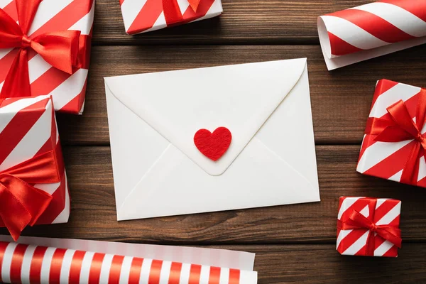 ギフトボックス付きバレンタインデーグリーティングカードヴィンテージ木製の背景と心の白い封筒 — ストック写真
