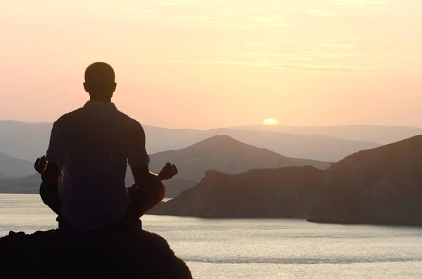 一个人在黎明时分在海边的荷花位置冥想瑜伽的轮廓 — 图库照片