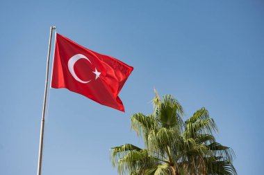 Türk bayrağı mavi gökyüzüne karşı rüzgarda dalgalanıyor