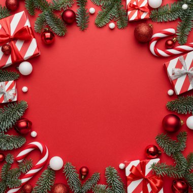 Kırmızı arkaplanda şablonu olan kırmızı Noel tasarımı. Düz konum, üst görünüm ve metin için boşluk kopyala
