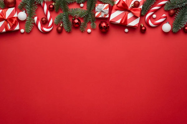 赤いクリスマスの背景には 休日の贈り物やお菓子の杖で飾られた国境 — ストック写真