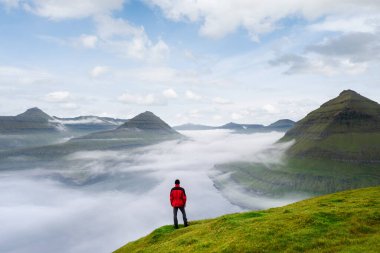 Faroe Adaları 'ndaki Eysturoy Adası' ndaki Funningur fiyordunun üzerinde sis var. Turistler güzel dağ manzaralarını severler.