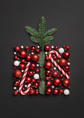 Kavramsal Noel kartı içinde şeker kamışı, Noel balosu ve köknar ağacı dallarından yapılmış siyah arkaplan hediye kutusu var.