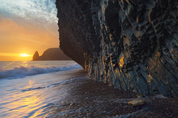 Havsstranden med vaggar och solnedgången — Stockfoto