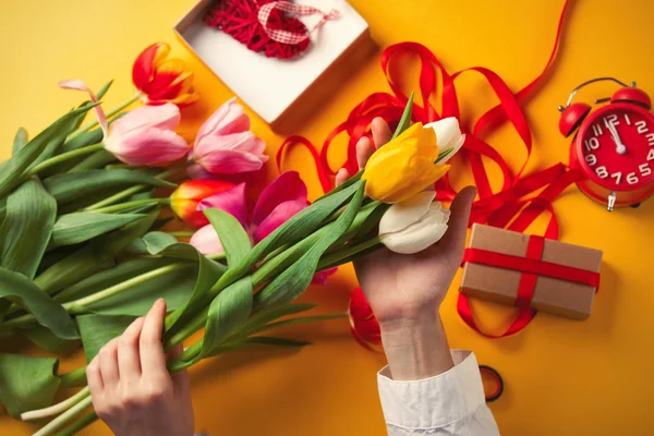 Kvinnliga händerna håller en tulpan blommor — Stockfoto