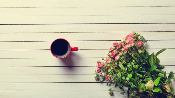 Buquê de rosas e xícara de café — Fotografia de Stock