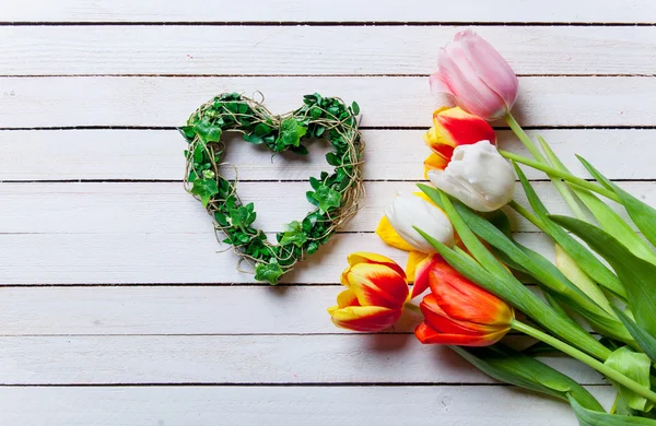 Bouquet di tulipani e regalo a forma di cuore — Foto Stock