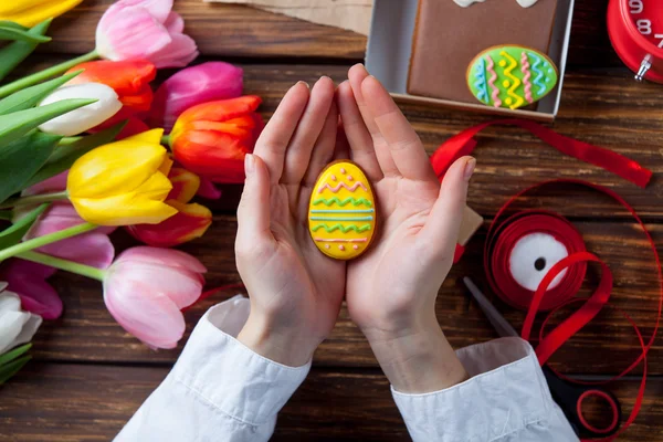 Vrouwelijke handen houden een cookie Paasei — Stockfoto